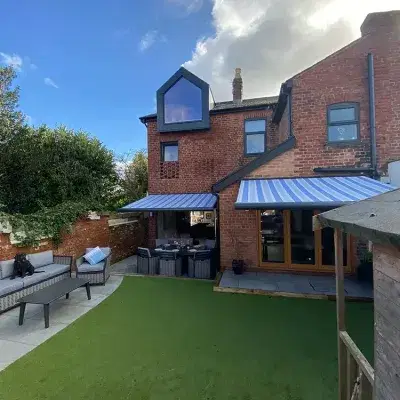 Blue stripy awnings covering a patio in a back garden