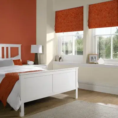 Orange roman blinds in a bedroom